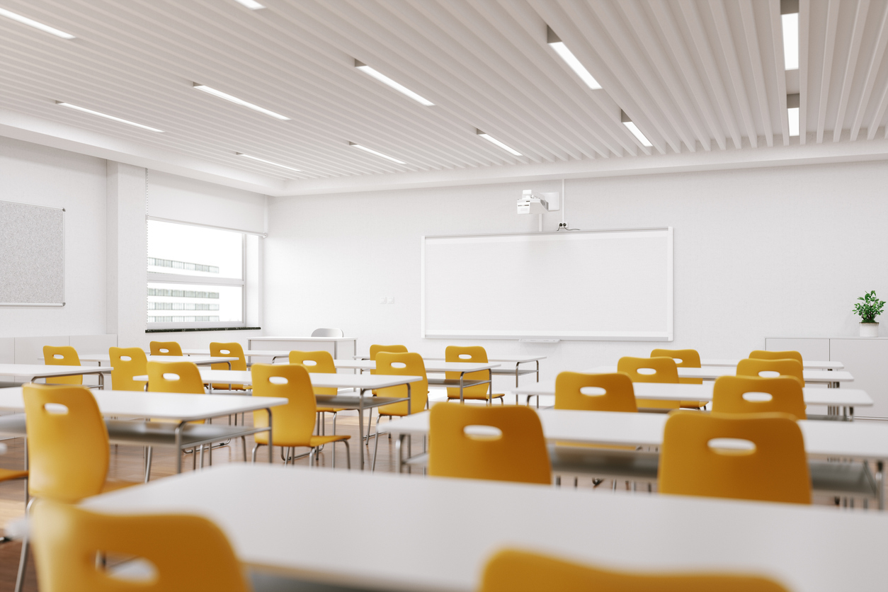 Interior of an empty modern classroom with interactive whiteboard and chairs.